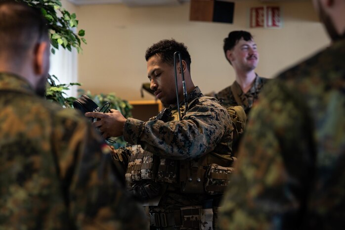 U.S. Marine Corps Lance Cpl. Michael Joyner tries on a German service member's gear during Exercise Cold Response 2022, Bodø, Norway, March 20, 2022. Joyner is a combat engineer with 2nd Combat Engineer Battalion, 2nd Marine Division. Exercise Cold Response '22 is a biennial Norwegian national readiness and defense exercise that takes place across Norway, with participation from each of its military services, as well as from 26 additional NATO allied nations and regional partners.