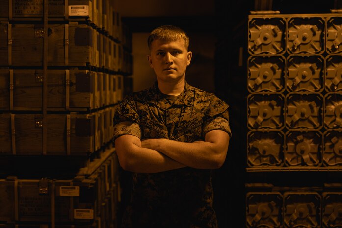 U.S. Marine Corps Cpl. Christian Jenkins, quality assurance safety observer with Headquarters and Headquarters Squadron, Marine Corps Air Station (MCAS) New River, Jacksonville, North Carolina, poses for a photo in front of aviation ordinances on MCAS New River in Jacksonville, North Carolina, March 24, 2022. Jenkins, the recipient of the March MCAS New River Go-Getter award, enlisted in the Marine Corps in 2018 from Sidney, Ohio. (U.S. Marine Corps photo by Lance Cpl. Antonino Mazzamuto)