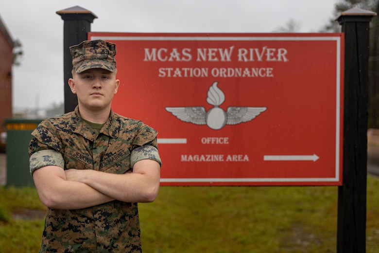 U.S. Marine Corps Cpl. Christian Jenkins, quality assurance safety observer with Headquarters and Headquarters Squadron, Marine Corps Air Station (MCAS) New River, Jacksonville, North Carolina, poses for a photo in front of the MCAS New River Station Ordinance building sign on MCAS New River in Jacksonville, North Carolina, March 24, 2022. Jenkins, the recipient of the March MCAS New River Go-Getter award, enlisted into the Marine Corps in 2018 from Sidney, Ohio. (U.S. Marine Corps photo by Lance Cpl. Antonino Mazzamuto)