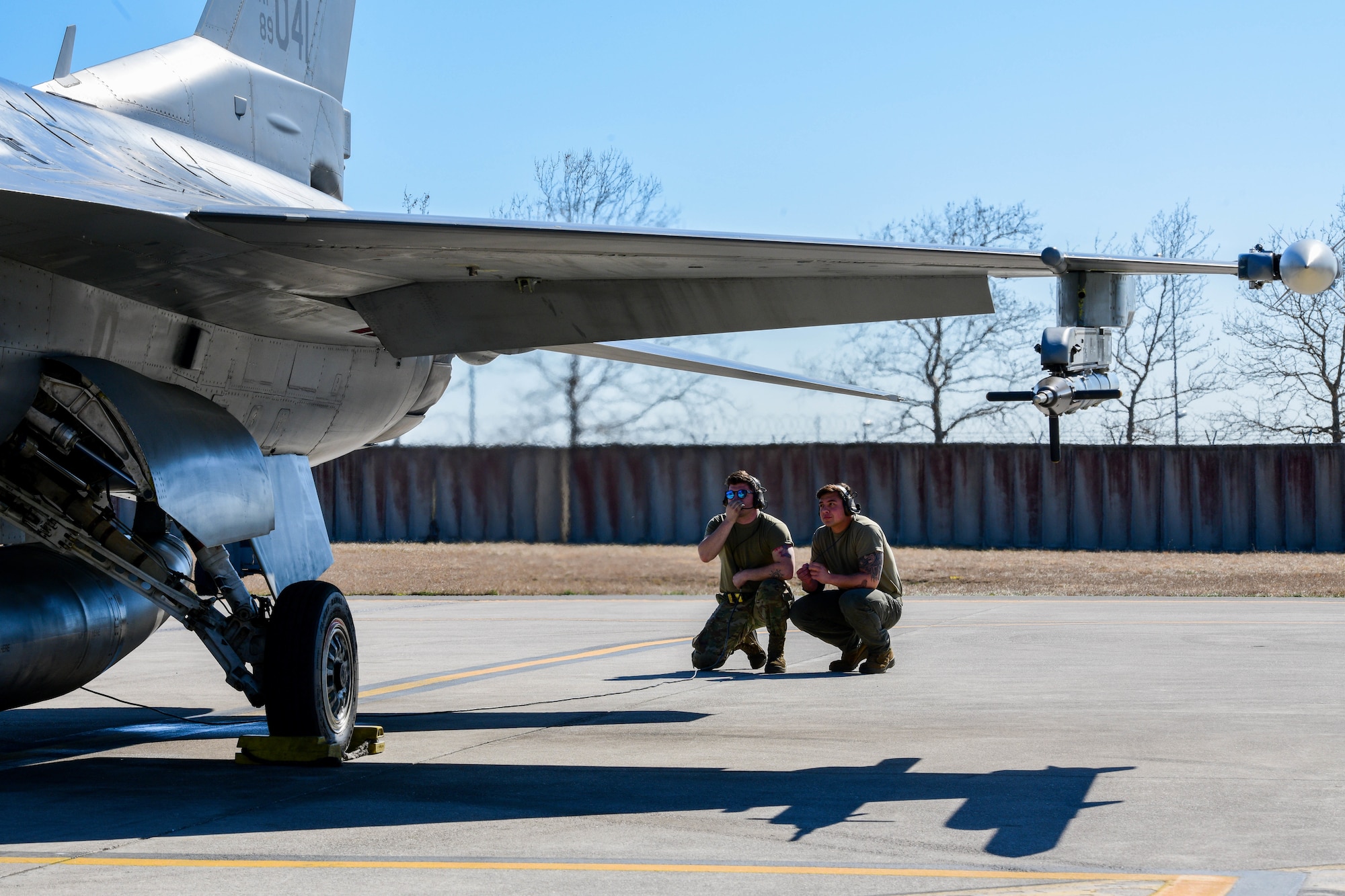 Senior Airman Ryan Munson and Senior Airman Tristan Marsh, 555th Aircraft Maintenance Unit F-16 Fighting Falcon crew chiefs, check flight control movement on an F-16 at Aviano Air Base, Italy, March 23, 2022. The 555th AMU’s operations support NATO’s statement of Alliance resolve and cohesion during enhanced air policing. Duties of a crew chief include overseeing daily maintenance, identifying malfunctions and replacing parts, conducting inspections and maintaining records, and coordinating aircraft care. (U.S. Air Force photo by Senior Airman Brooke Moeder)