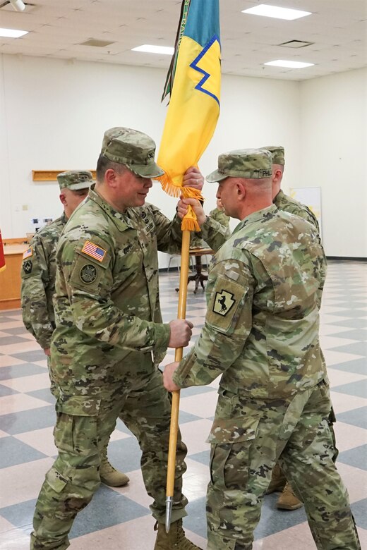 (Left to Right) Col. John Pippy, outgoing commander of the 55th Maneuver Enhancement Brigade, receives the brigade colors from Command Sgt. Maj. Shawn Phillips, command sergeant major of the 55th MEB, during the 55th MEB change-of-command ceremony at Fort Indiantown Gap, Pa., on March 26, 2022.