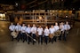 The Band of Flight poses in front of a model Wright Flyer in the National Museum of the United States Air Force