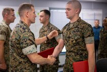 U.S. Marine Corps Col. George Markert, chief of staff with 2nd Marine Logistics Group, shakes hands with Cpl. Johnathan Ritter, an automotive maintenance technician with 2nd Maintenance Battalion, after he received a Navy and Marine Corps Achievement Medal at the II Marine Expeditionary Force (MEF) Innovation Campus during its grand opening on Camp Lejeune, North Carolina, April 1, 2022. The II MEF Innovation Campus is used to develop planning, cross-functional team building, creative problem-solving techniques, agile methodologies, idea generation frameworks, and 365/24/7 collaboration on a global scale in physical and virtual environments to maximize idea sharing, cross-domain collaboration, communication, and connectivity. (U.S. Marine Corps video created by Lance Cpl. Jessica J. Mazzamuto)
