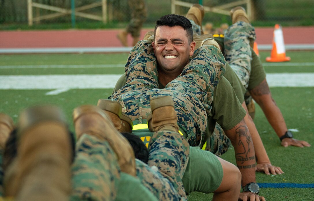 U.S. Marines with Sergeants School 4-22, conduct squad pushups during the Sergeants School Director’s Cup, Marine Corps Base Hawaii, March 30, 2022. The Director’s Cup is a squad competition conducted the day prior to graduation in order to boost morale, promote team building and reinforce esprit de corps. (U.S. Marine Corps photo by Lance Cpl. Chandler Stacy)