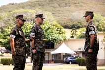 U.S. Marine Corps Sgt. Maj. Jose Romero, left, offgoing sergeant major, Headquarters Battalion, Marine Corps Base Hawaii, Sgt. Maj. Matthew Kidder, middle, incoming sergeant major, and Lt. Col. Stephen McNeil, right, commanding officer, Headquarters Battalion, MCBH, conduct a relief and appointment ceremony, MCBH, March 30, 2022. Romero was relieved as the sergeant major of Headquarters Battalion by Kidder. (U.S. Marine Corps photo by Cpl. Brandon Aultman)