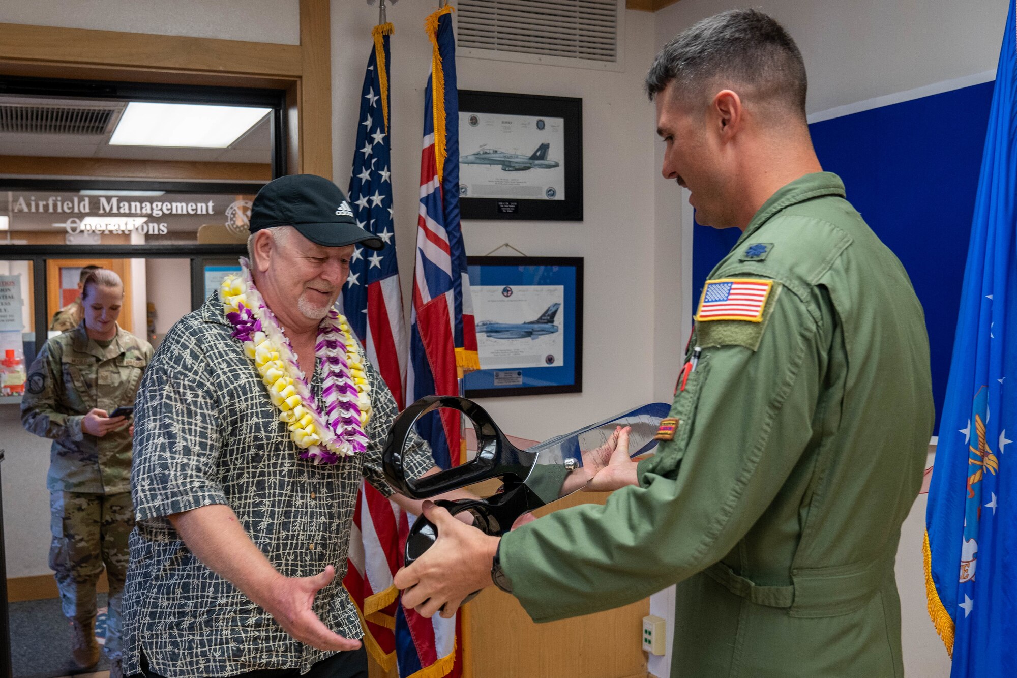 Lt. Col. Scott Durham, 15th Operations Support Squadron commander, and Retired Chief Master Sgt. Larry Smith, prepare to cut the ribbon during a conference room renaming ceremony at Joint Base Pearl Harbor-Hickam, Hawaii, March 30, 2022. The conference room was renamed the Larry Smith Mission and Planning Room in honor of Smith’s 44 years of service in the Air Force and decades of support to the 15th Operations Group. (U.S. Air Force photo by Airman 1st Class Makensie Cooper)