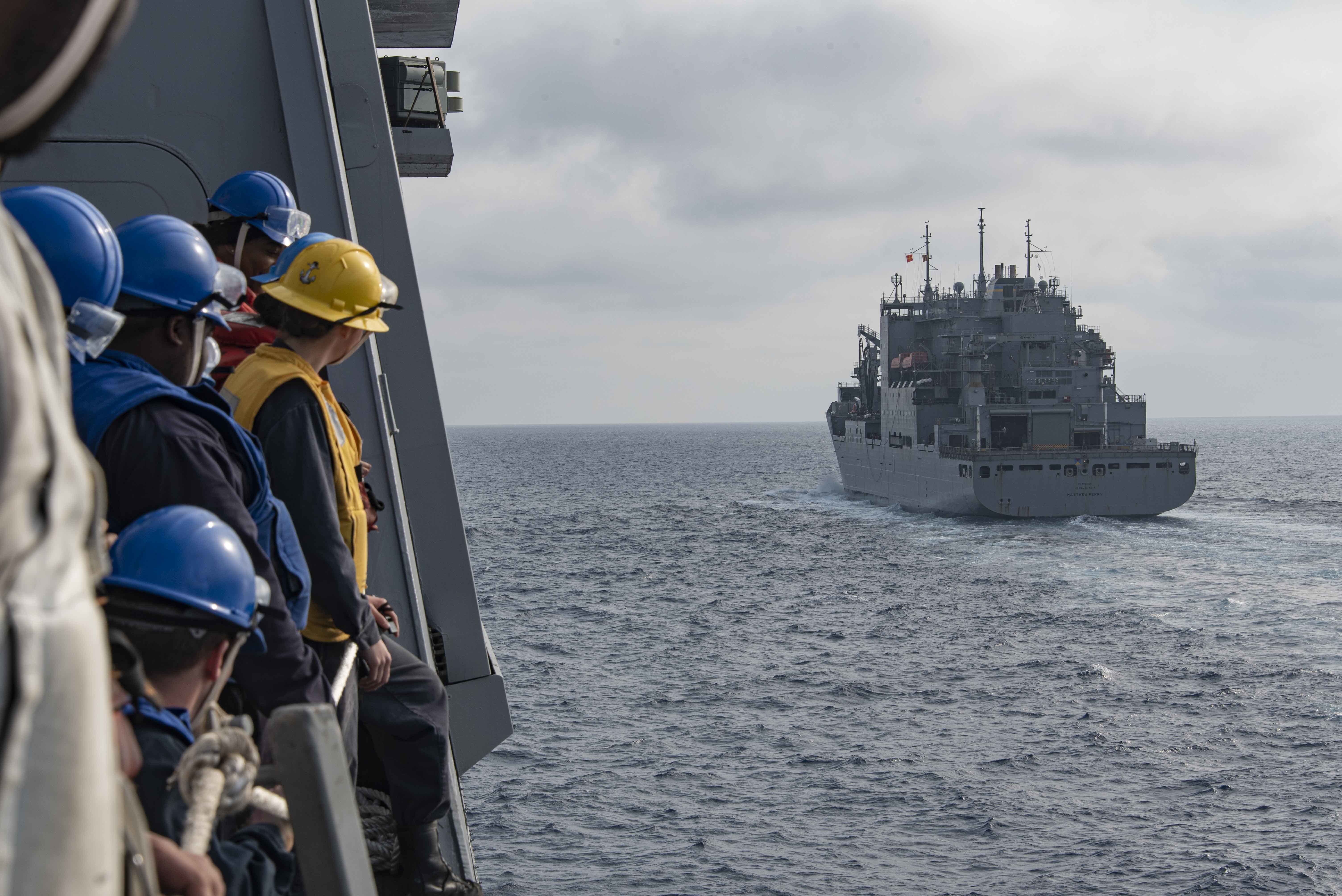 Sailors assigned to USS New Orleans (LPD 28) stand by on in the ship’s boat valley while approaching USNS Matthew Perry (T-AKE 9) for an underway replenishment-at-sea certification, March 15, 2022.