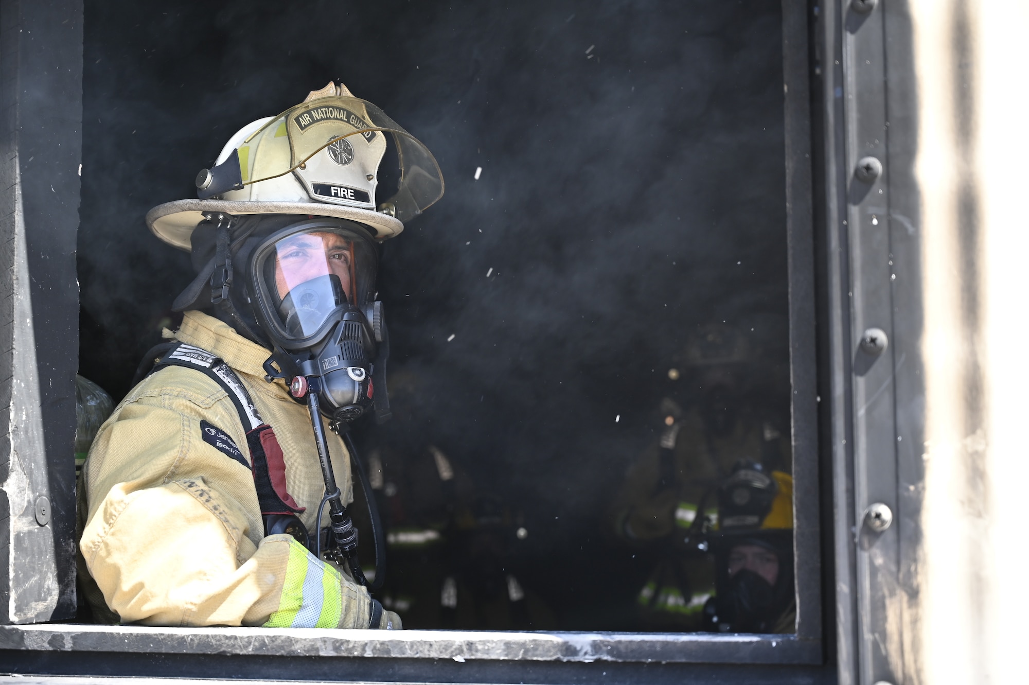 Master Sgt. Jose Ordaz, a firefighter with the 162nd Civil Engineer Squadron, looks out a window of the live-fire house at Davis-Monthan Air Force Base, Arizona. Guardsmen from the 162nd Wing partner with firefighters at D-M every year to conduct realistic and dynaimc training at the active duty base's robust facilities. (U.S. Air National Guard photo by Maj. Mary Hook)