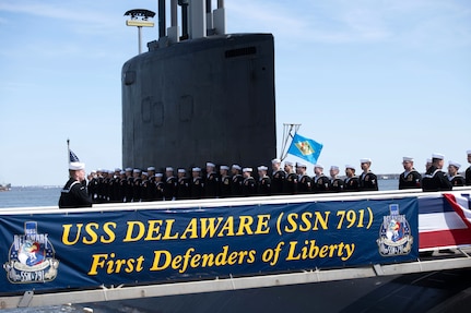 The crew of the Virginia-class submarine USS Delaware (SSN 791) board the ship during a commissioning commemoration ceremony in Wilmington, Delaware April 2, 2022.