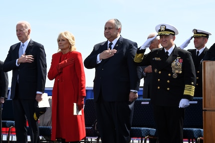 President of the United States Joe Biden, First Lady Jill Biden, Secretary of the Navy Carlos Del Toro, and Chief of Naval Operations Adm. Mike Gilday stand during the national anthem during a commissioning commemoration ceremony for the Virginia-class submarine USS Delaware (SSN 791) in Wilmington, Delaware April 2, 2022.