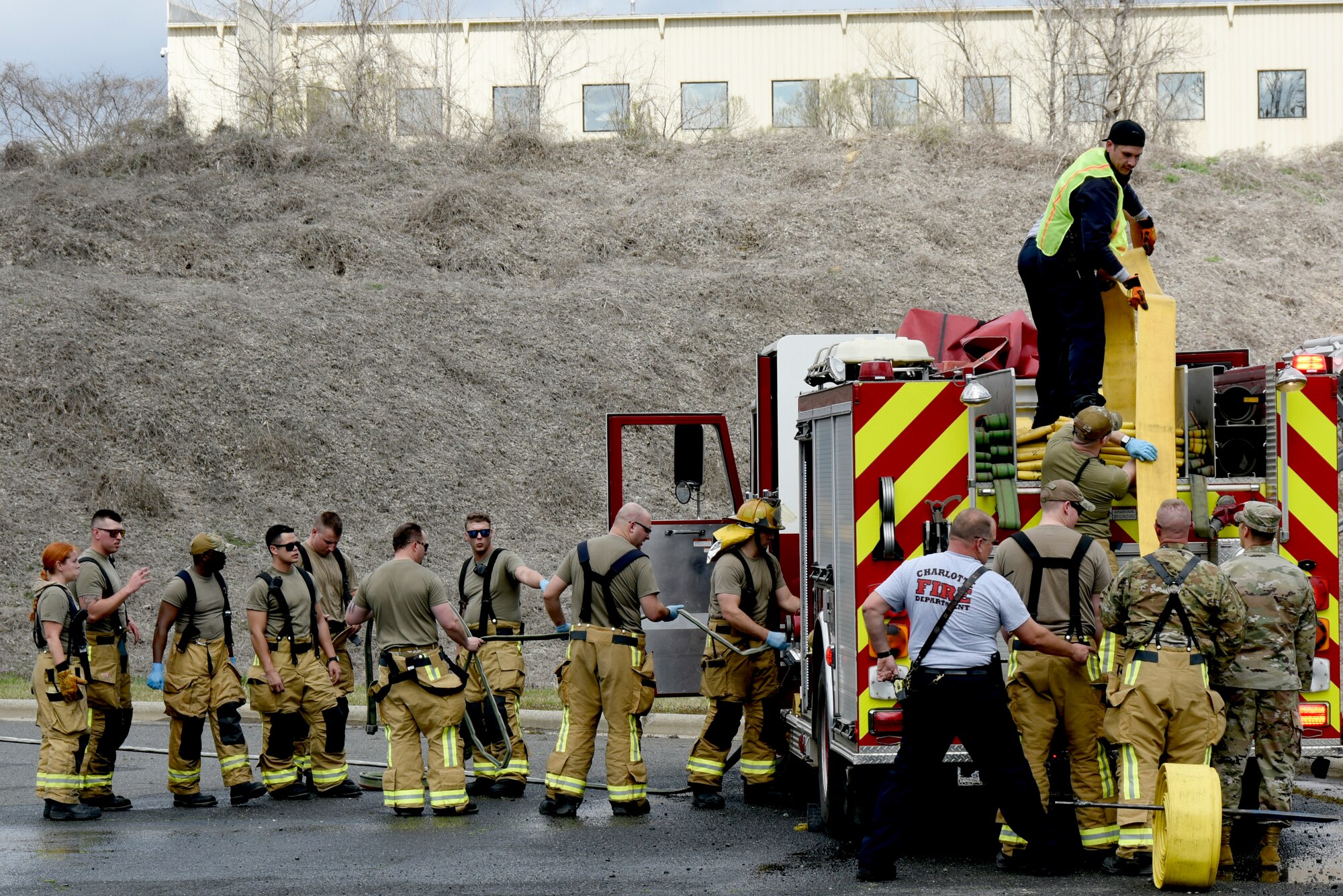 U.S. Airmen assigned to the North Carolina Air National Guard (NCANG), 145th Civil Engineering Squadron (CES), with the assistance from Charlotte Fire Department members, roll up their fire hoses after successfully attempting to extinguish a simulated aircraft mishap just outside the NCANG Base, Charlotte Douglas International Airport, Mar. 6, 2022. The 145th CES coordinated with the Charlotte Fire Department and other local authorities to simulate an aircraft mishap and what steps to handle in the event of such a disaster. This is the first exercise of this kind since the 1990s involving many moving parts including local fire departments, Emergency Management and the 145th Airlift Wing.