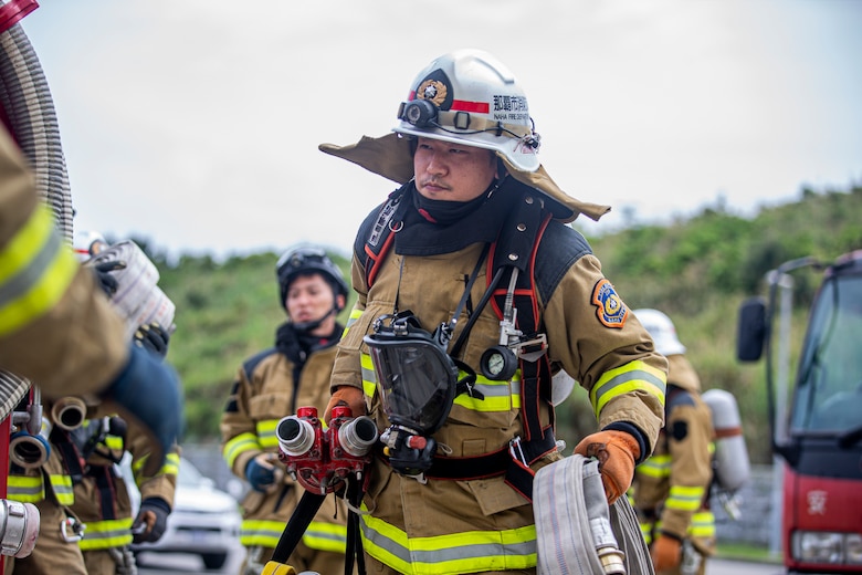 那覇市消防局の消防士が、沖縄県金武町にある海兵隊消防訓練施設での実動訓練で火災に対応。この訓練は、日米が実際に火を使った訓練で、同じ任務を達成するために使用するさまざまな消火技術と方法を比較するための消火訓練です。