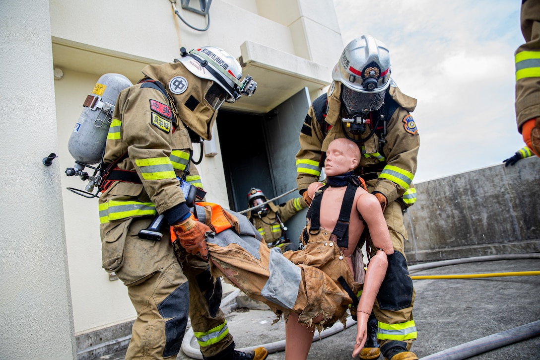 那覇市消防局の消防士が、沖縄県金武町にある海兵隊消防訓練施設での実動訓練で火災に対応、ダミーの犠牲者を救出。この訓練は、日米が実際に火を使った訓練で、同じ任務を達成するために使用するさまざまな消火技術と方法を比較するための消火訓練です。