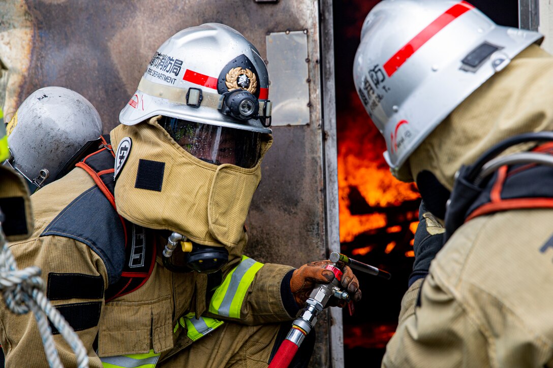 那覇市消防局の消防士が、海兵隊消防訓練施設での実動訓練で火災に対応。この訓練は、日米が実際に火を使った訓練で、同じ任務を達成するために使用するさまざまな消火技術と方法を比較するための消火訓練です。
