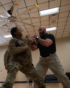 Airman 1st Class Morgan Dey spars with Billy Matheny during a women's self defense class.