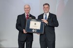 David Kless and Michael Broderick stand with a plaque