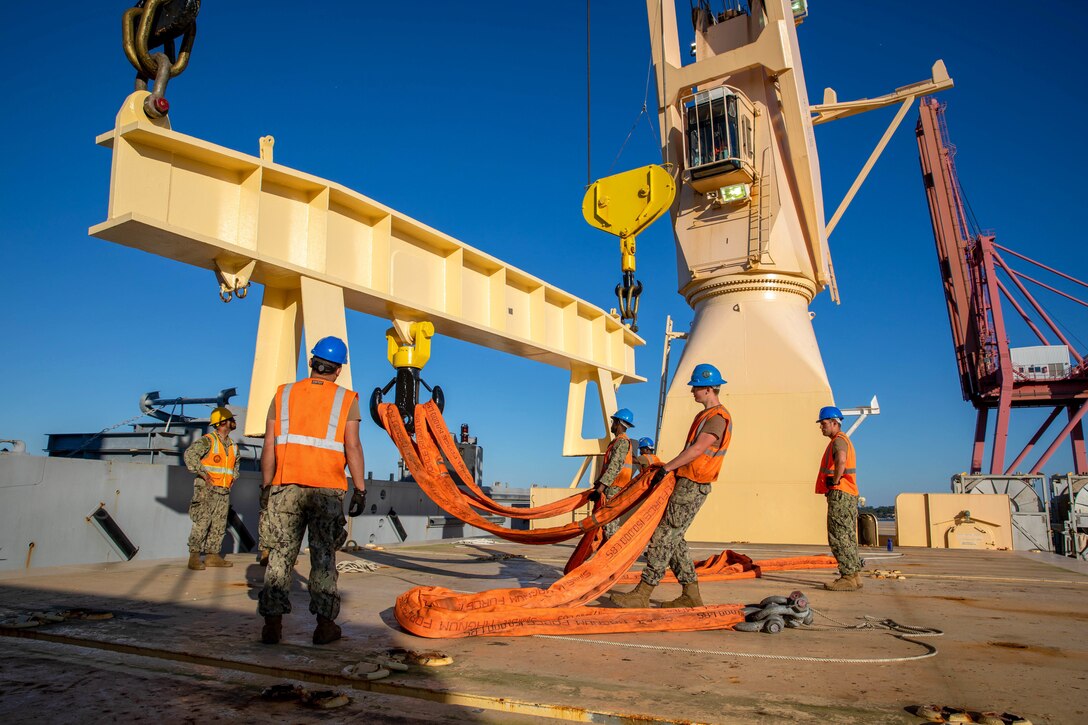 Sailors work with a large crane.