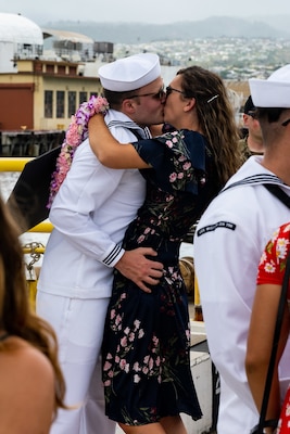 Information Systems Technician (Submarines) 1st Class Brenden Crutchfield, from Burleson, Texas, assigned to the Virginia-class fast-attack submarine USS Missouri (SSN 780) kisses his wife after the boat returns to Joint Base Pearl Harbor-Hickam from deployment in the 7th Fleet area of responsibility.