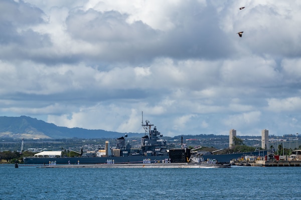 The Virginia-class fast-attack submarine USS Missouri (SSN 780) passes the battleship USS Missouri (BB 63) Memorial as the boat returns to Joint Base Pearl Harbor-Hickam from deployment in the 7th Fleet area of responsibility.