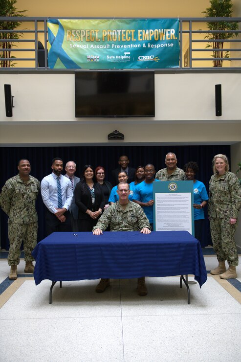 Vice Adm. Yancy B. Lindsey, Commander, Navy Installations Command (CNIC), takes a photo with senior leaders, sexual assault response coordinators and unit victim advocates during the Sexual Assault Awareness and Prevention Month proclamation signing event at CNIC headquarters on board the historic Washington Navy Yard, March 24, 2022.