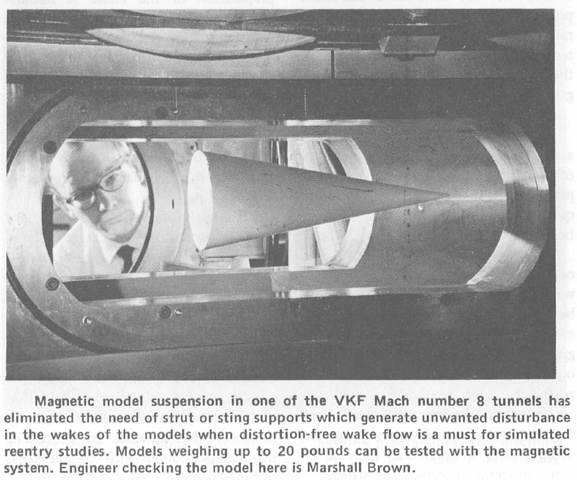A former AEDC engineer checks a model suspended in the Tunnel E wind tunnel at Arnold Air Force Base in January 1972. In Tunnel E, a magnetic model support system (MMSS) was used, which eliminated the need for strut or sting supports.
