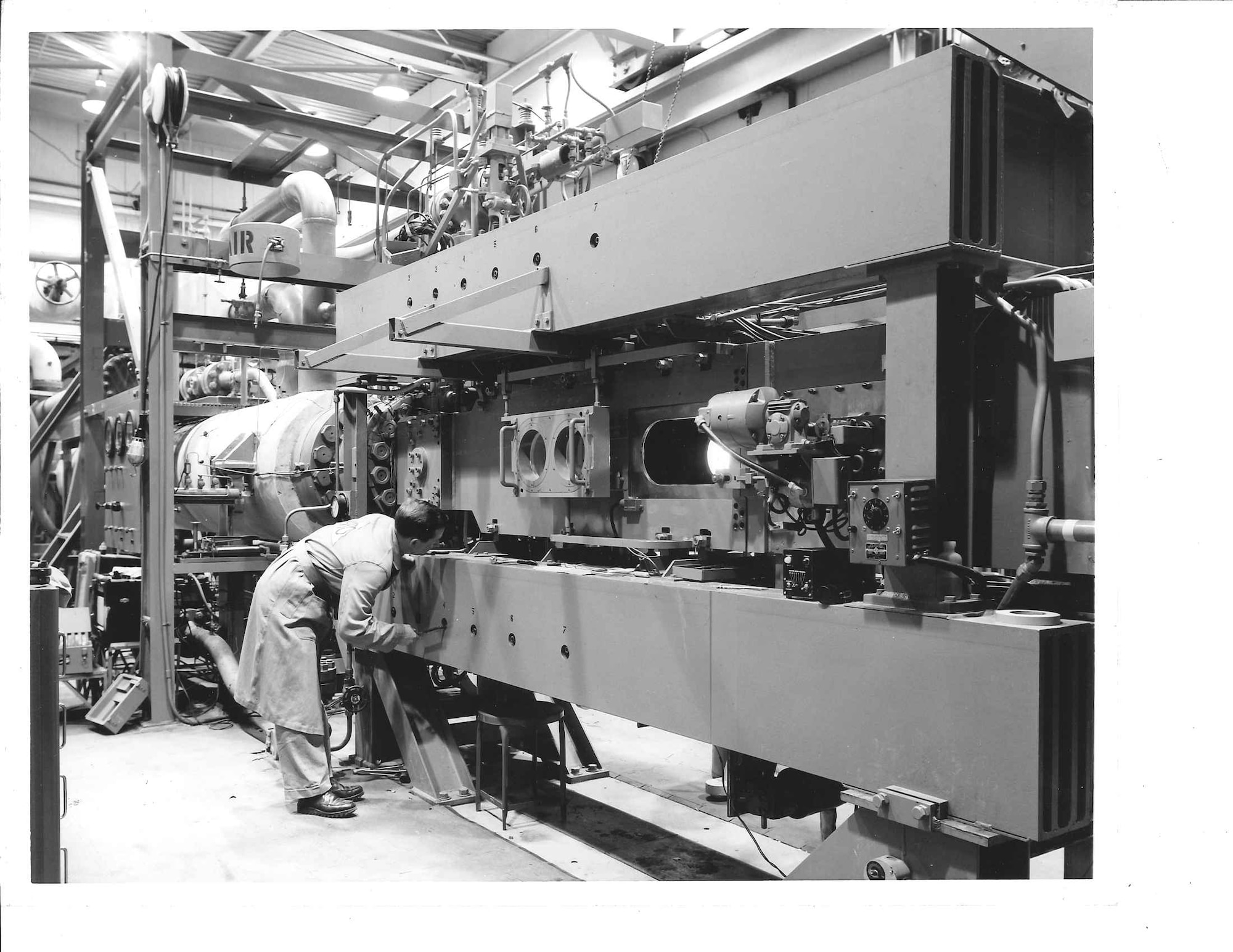 A technician inspects the adjustment mechanism for the original two-dimensional flexible wall variable Mach-number nozzle of the original configuration of Tunnel E.