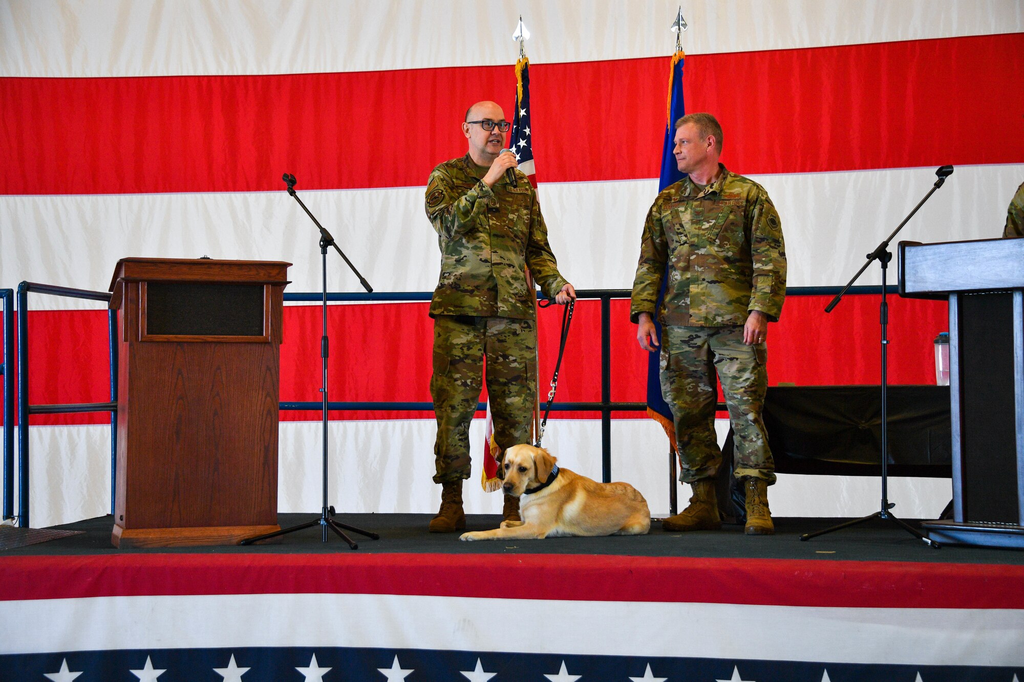 Senior Master Sgt. Jim Harper, 301st Fighter Wing Mental Health Specialist, and Col. Allen Duckworth, 301st Fighter Wing Commander, speaks to an audience at Naval Air Station Joint Reserve Base Fort Worth, Texas on April 03, 2022. Col. Duckworth introduced Dallas, 301 FW therapy dog, to the wing. (U.S. Air Force photo by Staff Sgt. Nije Hightower)