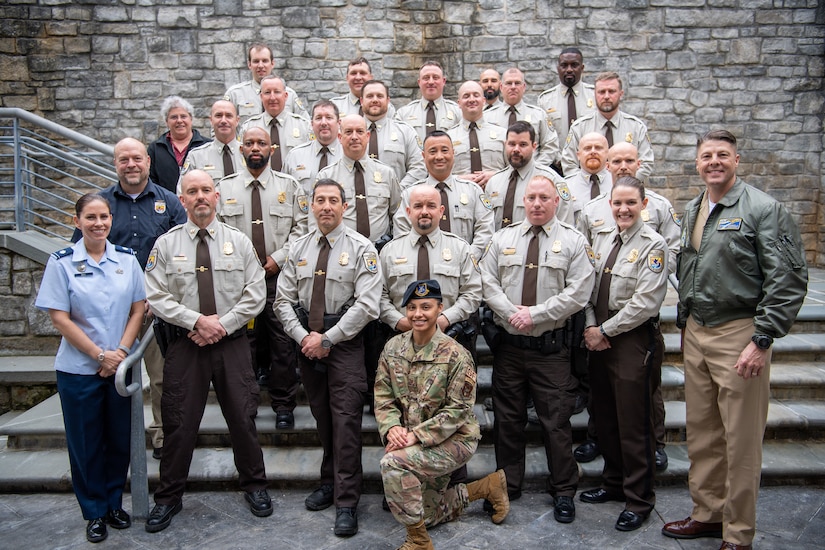 A group of U.S. Fish and Wildlife Law Enforcement officers and service members pose for a photo.
