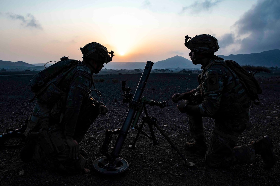 Two soldiers set up a mortar.