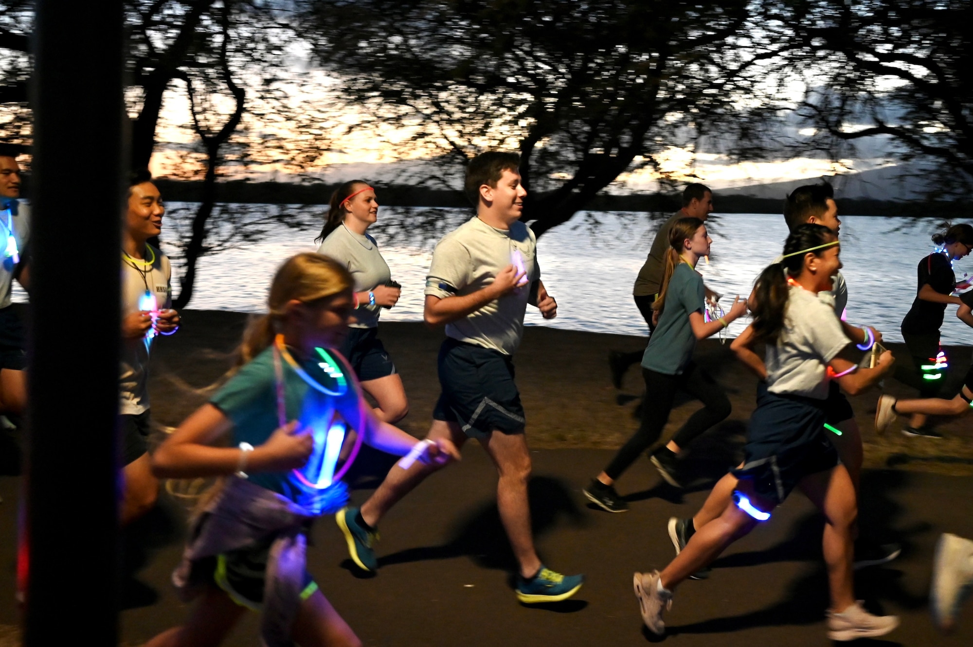 Airmen and their families participate in the Sexual Assault Awareness and Prevention Month glow run at Joint Base Pearl Harbor-Hickam, Hawaii, April 1, 2022. The 15th Wing Sexual Assault Prevention and Response Office hosted a glow fun 5k to raise awareness about the resources their office provides and sexual assault in the military. (U.S. Air Force photo by 1st Lt. Benjamin Aronson)