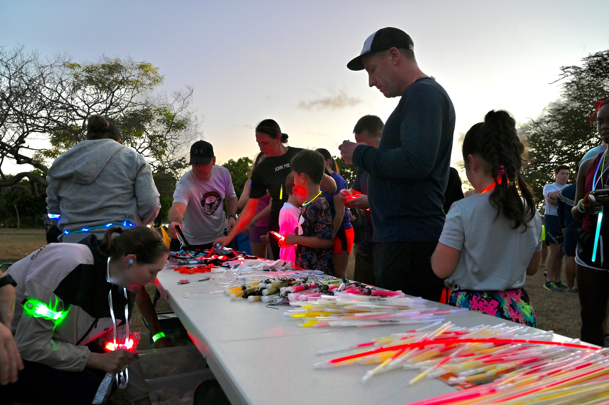 Glow sticks and bracelets are given out to Airmen and their families as part of the Sexual Assault Awareness and Prevention Month glow run at Joint Base Pearl Harbor-Hickam, Hawaii, April 1, 2022. April is designated as SAAPM and this year the Department of Defense’s theme is to step forward and highlight the power of acts that can bolster prevention, increase reporting, and promote advocacy for a safer DoD community. (U.S. Air Force photo by 1st Lt. Benjamin Aronson)