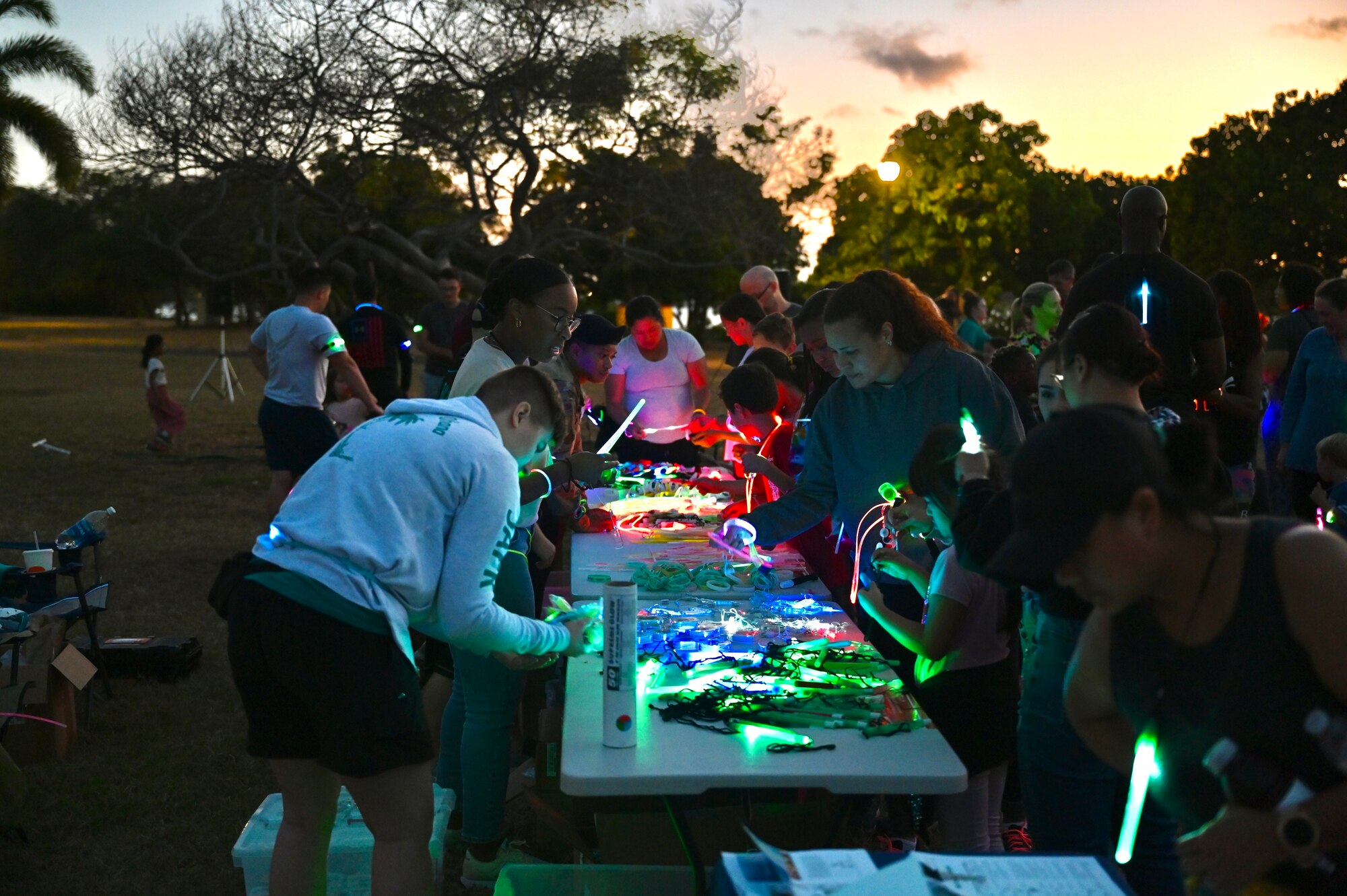 Volunteers hand out glow sticks and bracelets to Airmen and their families at the Sexual Assault Awareness and Prevention Month glow run at Joint Base Pearl Harbor-Hickam, Hawaii, April 1, 2022. The theme of SAAPM this year is a call to action for individuals at all levels of the Department of Defense to use their personal strength to advance positive change in preventing sexual violence. (U.S. Air Force photo by 1st Lt. Benjamin Aronson)