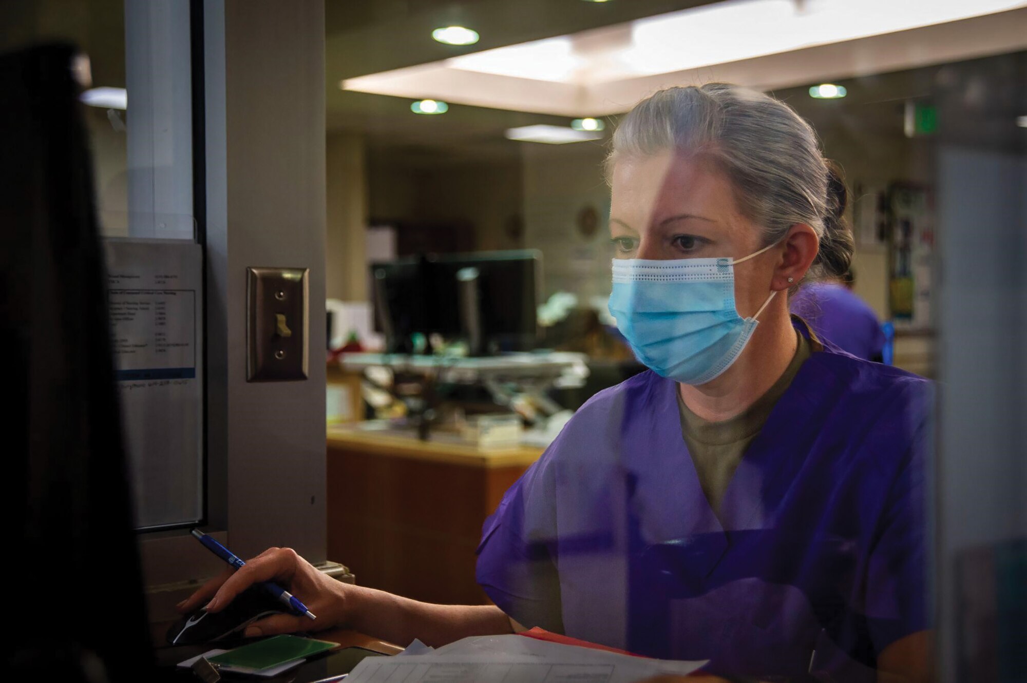 Capt. Brittney Snider, 445th Aeromedical Staging Squadron clinical nurse, reviews patient information at Naval Medical Center San Diego’s intensive care unit as part of joint training with their Navy counterparts, March 16, 2022.