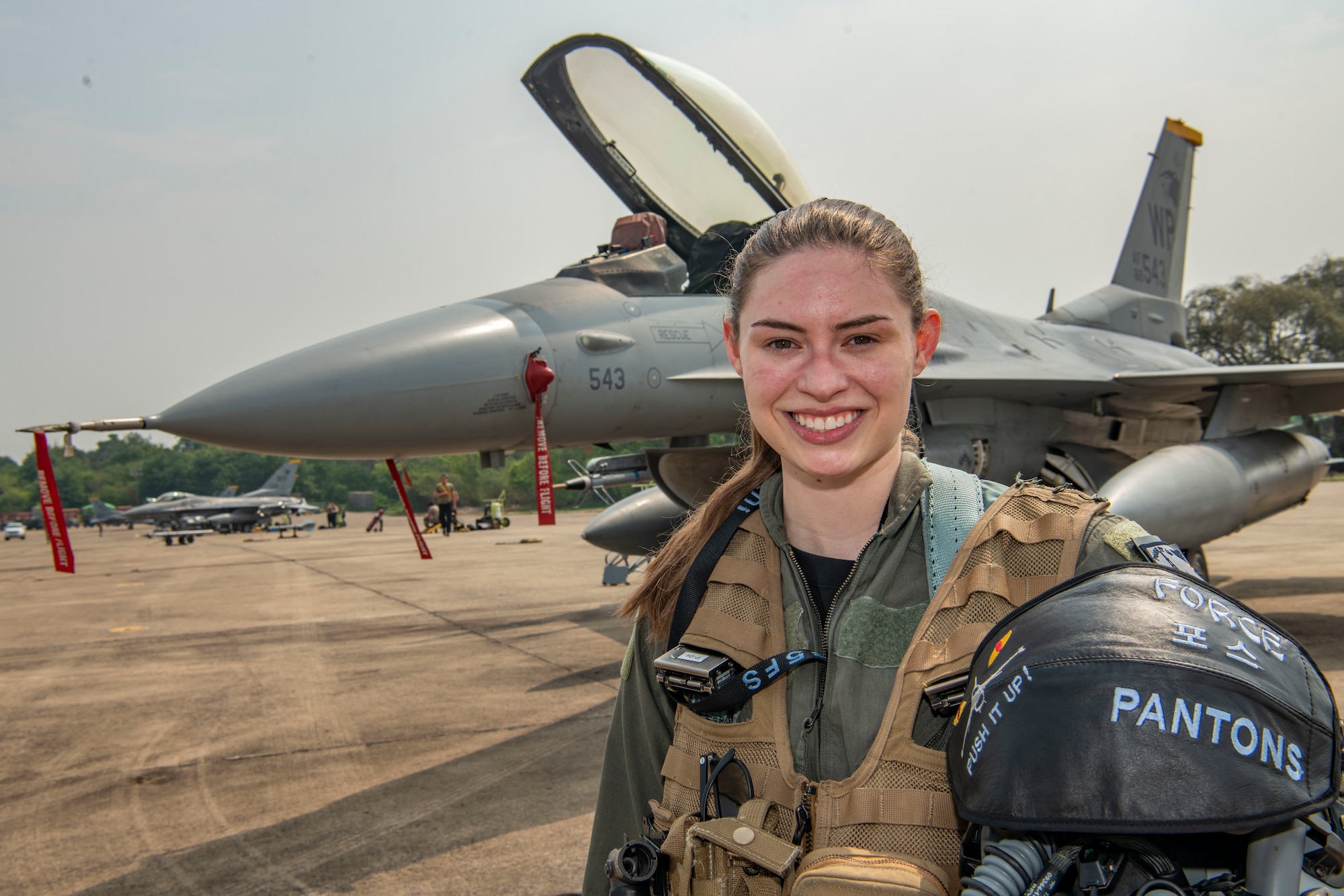 First Lt. Samantha “Force” Colombo, 35th Fighter Squadron pilot, stands in front of an F-16 Fighting Falcon after returning from a flight during Cope Tiger 2022 at Korat Royal Thai Air Base, Thailand, March 18, 2022. Female fighter pilots officially started flying for the U.S. Air Force in the 1990s. (U.S. Air Force photo by Staff Sgt. Jesenia Landaverde)