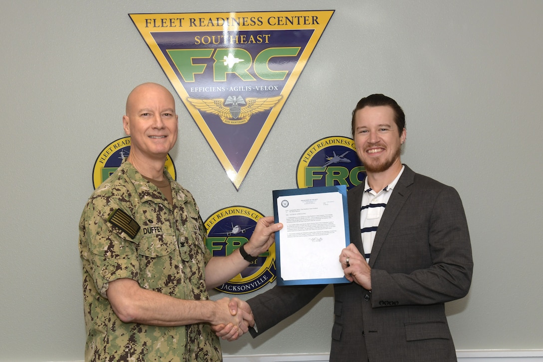 Fleet Readiness Center Southeast (FRCSE) Commanding Officer Capt. Grady Duffey presents Senior Aerospace Engineer, David Anderson, with FRCSE’s 2021 Dora Quinlan Mentor Award. The award is named after former FRCSE Business Operations Director, Dora Quinlan, who earned the first mentor of the year award from Commander, Fleet Readiness Centers. Quinlan lost her battle with cancer in 2016.