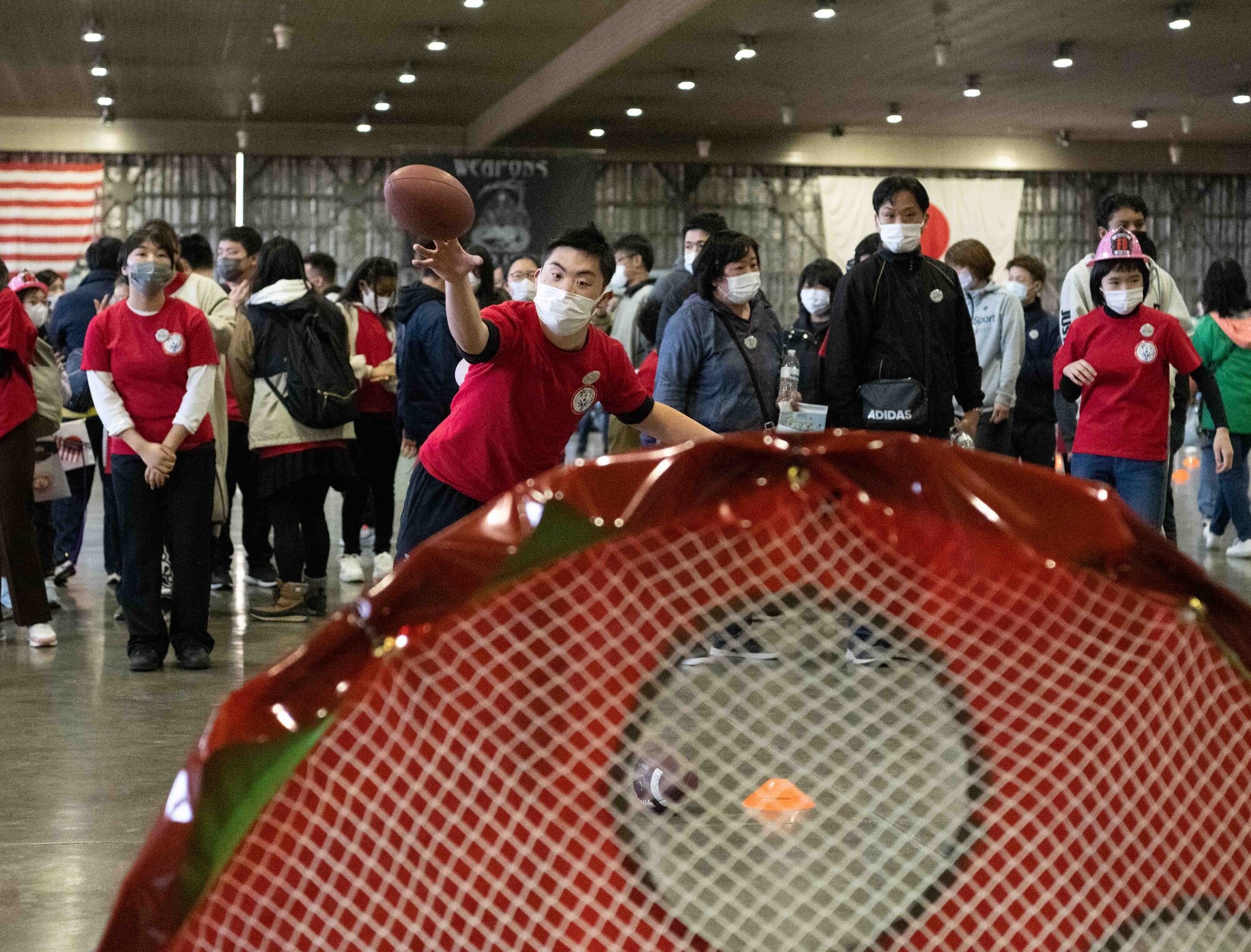 An athlete of the 2022 Misawa Special Olympics throws a football into a goal during one of the games.