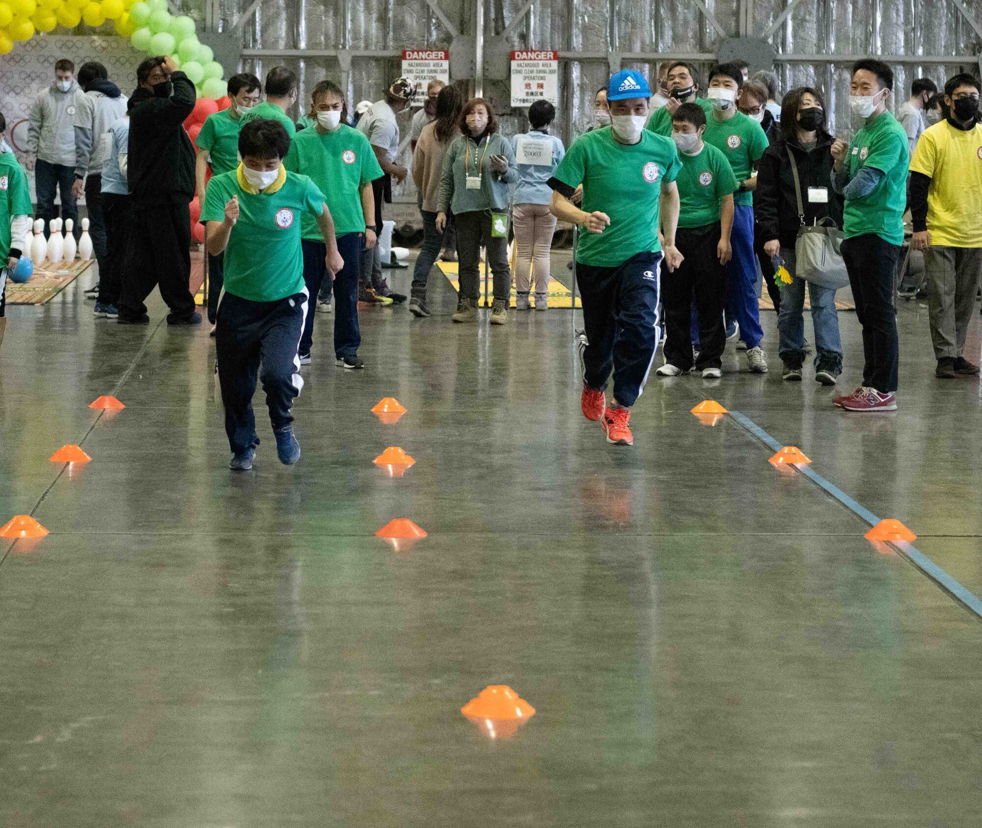 Two athletes of the 2022 Misawa Special Olympics race against each other during one of the games.