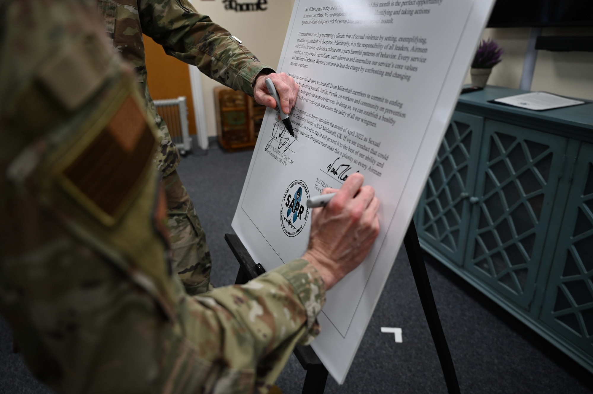 U.S. Air Force Col. Jason Herring, 100th Air Refuling Wing vice commander, and U.S. Air Force Col. Jason Culinga, 352nd Special Operations Wing vice commander, sign a proclamation designating April as Sexual Assault Awareness and Prevention Month at Royal Air Force Mildenhall, England, April 1, 2022. Protecting Airmen against sexual assault contributes to a ready force capable of executing the mission. (U.S. Air Force photo by Airman 1st Class Viviam Chiu).