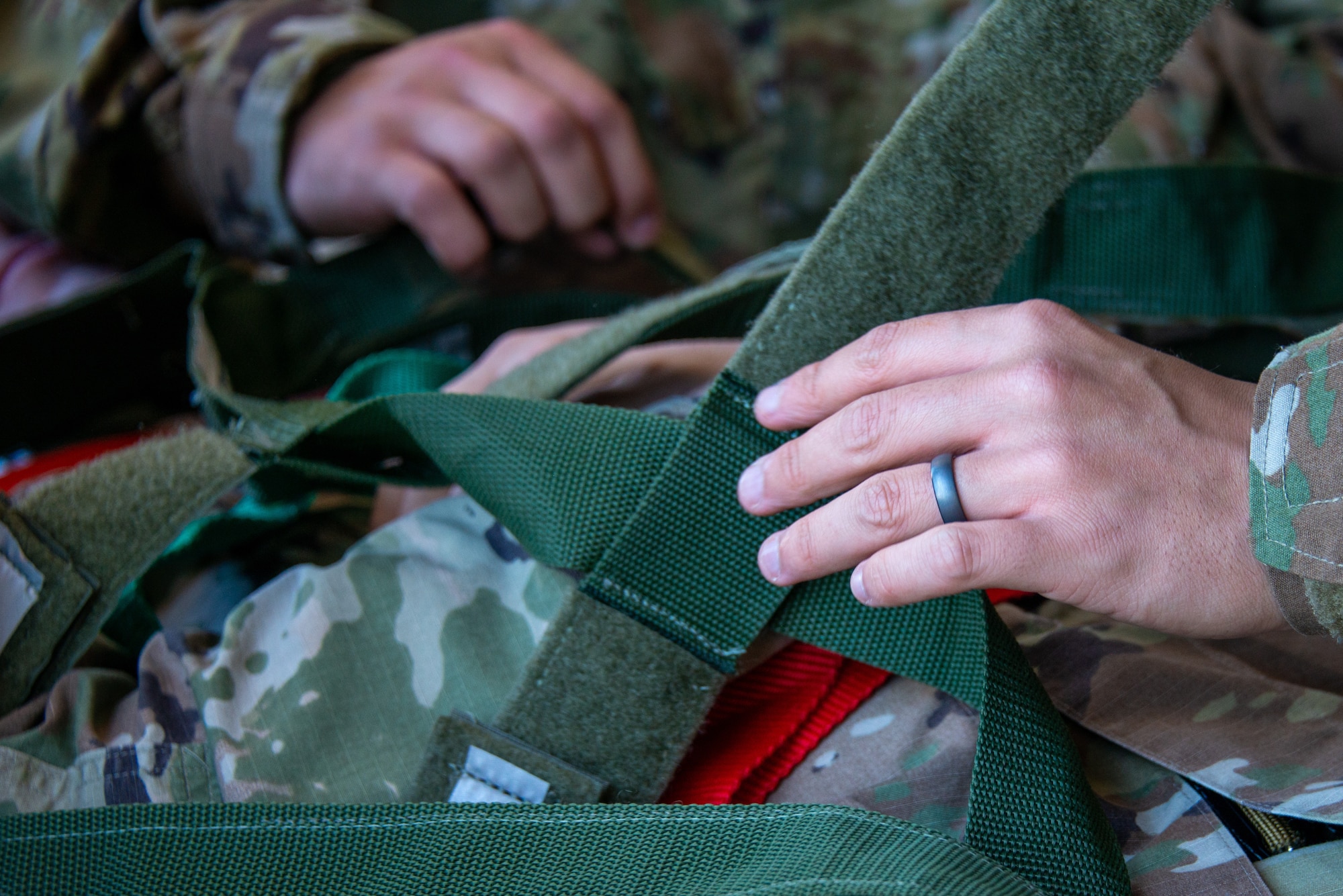 close up of Airmen securing a simulated patient to a backboard