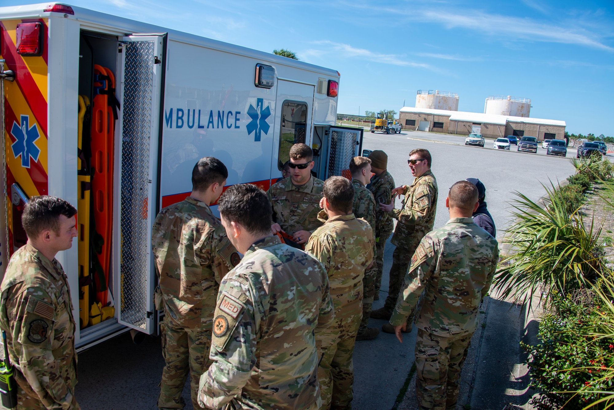 military members stand beside ambulance