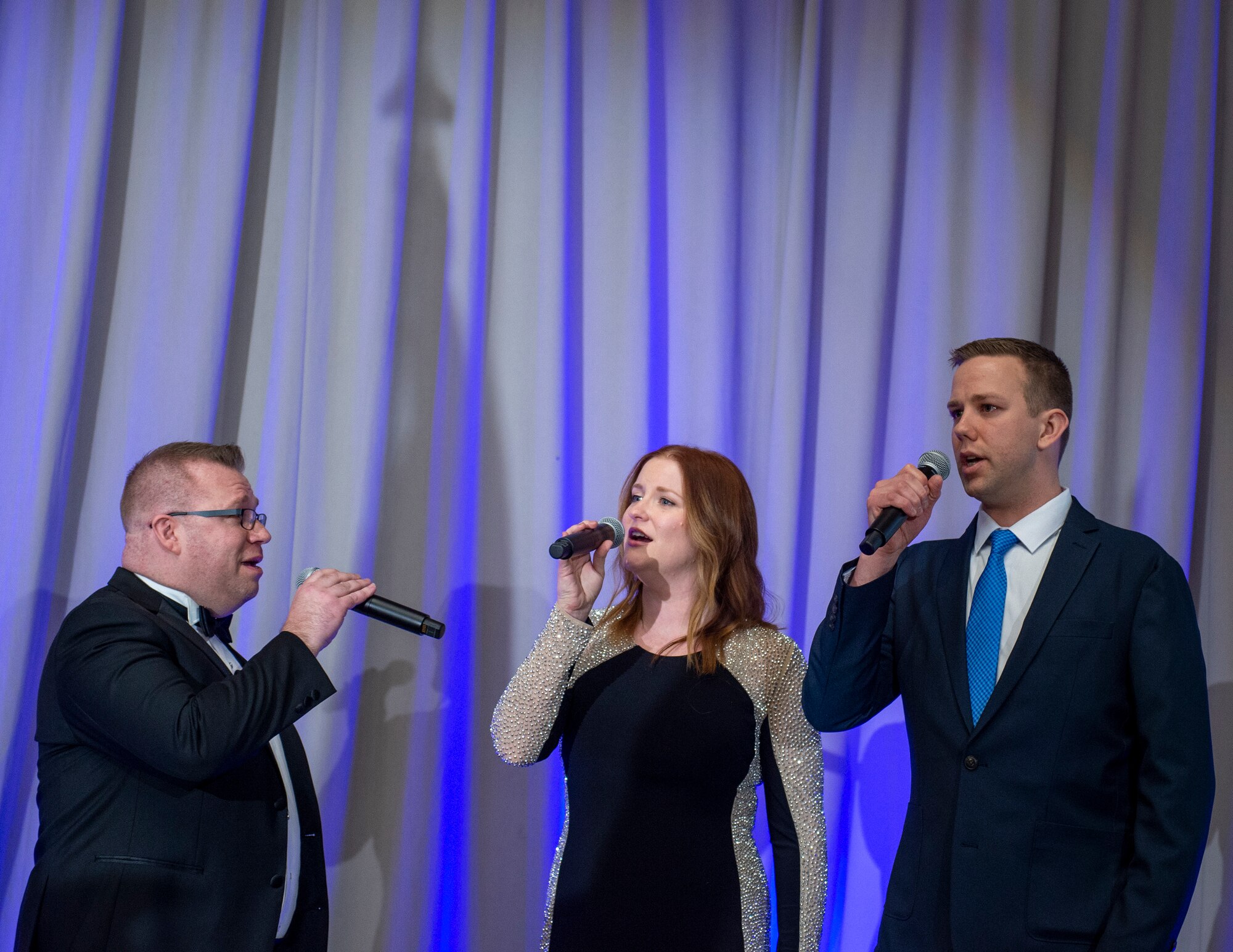 U.S. Air Force Master Sgt.’s Ryan Ringwelski, left, and Jessica Lewellen, center, and Tech. Sgt. James Taylor, right, 133rd Airlift Wing, sing the national anthem in St. Paul, Minn., March 19, 2022.