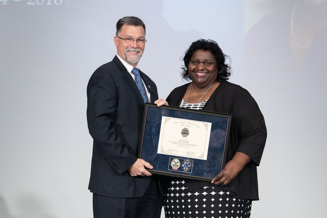 Lula Manley and David Kless hold a plaque