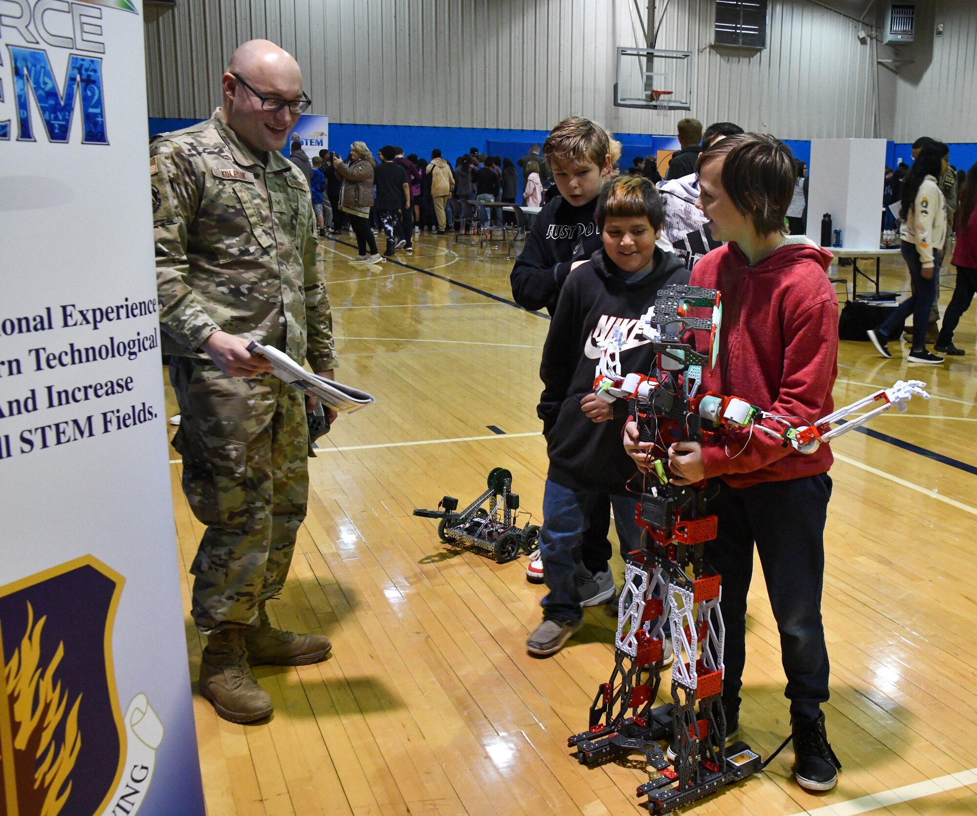 An Altus Junior High School student hugs a Meccano robot at Altus High School, Altus, Oklahoma, March 30, 2022. Altus Air Force Base’s Science, Technology, Engineering and Mathematics (STEM) Council provided two different types of robots and a drone for this year’s STEM fair. (U.S. Air Force photo by Airman 1st Class Miyah Gray)