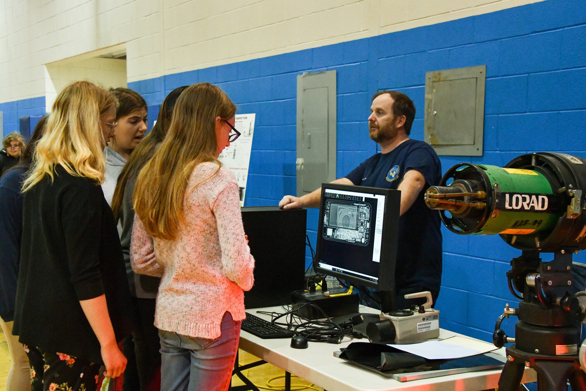 Nathan Bucholzer, 97th Maintenance Squadron nondestructive inspection technician (NDI), explains his job to a group of Altus Junior High School students at Altus High School, Altus, Oklahoma, March 30, 2022. NDIs test for defects in structures, vessels and vehicles using different techniques including ultrasonic, electromagnetic and dye penetrant testing. (U.S. Air Force photo by Airman 1st Class Miyah Gray)