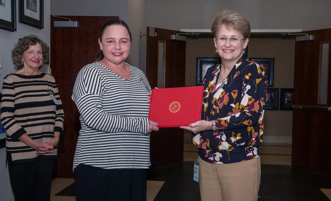 Kristal Humphrey, right, civilian human resources director for Marine Corps Installations (MCI) East, presents a Certificate of Commendation to Jennifer Archer, center, human resources specialist for Marine Corps Air Station (MCAS) Cherry Point, at an award ceremony at MCAS Cherry Point, North Carolina, March 15, 2021. Archer was recognized as Civilian of the Year for leading her team’s efforts to negotiate contracts between MCAS Cherry Point and various labor unions. (U.S. Marine Corps photo by Lance Cpl. Lauralle Walker)