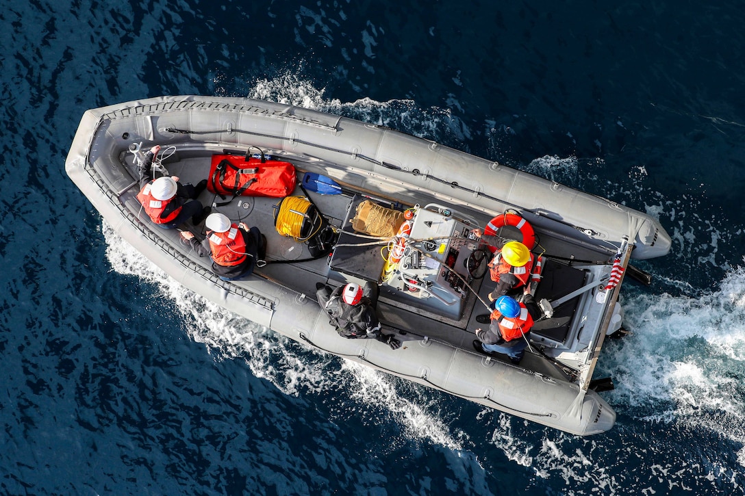 An aerial view of sailors in a small boat.