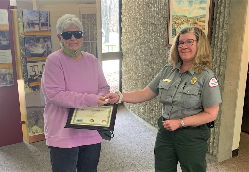 On April 4, 2022,  the Truman Lake team presented Truman Lake Volunteer Donna Terry  with the National Volunteer Award which is sponsored by the U.S. Army Corps of Engineers and the Corps Foundation. Park Ranger Erin Cordrey presented the award to her. Donna has been volunteering with us for a dozen plus years, wearing MANY hats throughout.  Most recently, Donna has assisted us with litter pick-up, mulching and weeding flower beds, as well as invasive species management. Earlier this season, and most every season from 2010 to 2021, Donna has been a volunteer visitor attendant at the Harry S. Truman Visitor Center.  In that capacity Donna has been our go-to for working countless weekends with high visitation, at times even working alone.  Donna doesn’t simply say “hello” to each person who enters the Visitor Center—she takes the time to personally give a warm, heartfelt welcome to every single visitor. She delights in teaching youngsters about water safety by giving out coloring books, iron-ons, cups, etc.  Donna also excels in making our Veterans know how much they are appreciated—she personally thanks everyone she encounters with a sincere “Thank you for your service.”