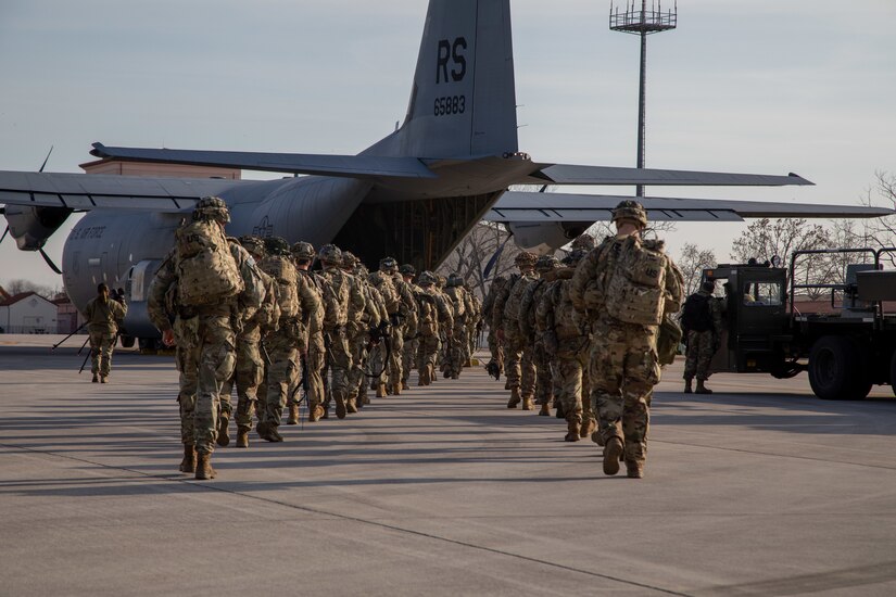 Paratroopers board a military aircraft.