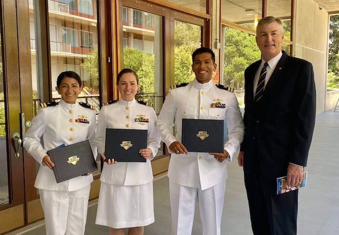 IMAGE: From left to right, Lt. Sasha Barnett, Lt. Cmdr. Allison Pelosi; Lt. Erick Samayoa; and John Hammerer, Chair of Integrated Air and Missile Defense at the Naval Postgraduate School; gather after the graduation ceremony for the Spring 2021 quarter on June 18, 2021 outside King Hall Auditorium at the Naval Post Graduate School.