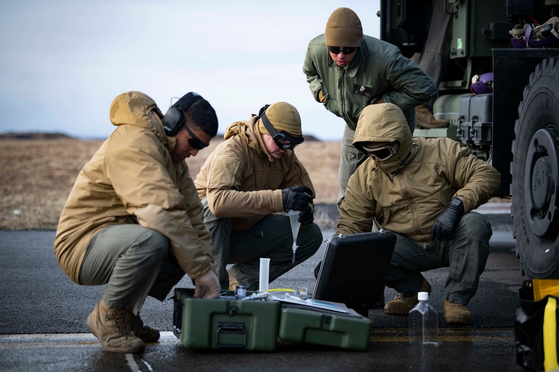 Sgt. Matthew Dungan, center right, a native of Lebanon, Missouri, assigned to Marine Wing Support Squadron 271, monitors members of MWSS 271 and Navy Cargo Handling Battalion 1 testing fuel during a fixed wing refueling operation as part of exercise Northern Viking 22 on Keflavik Air Base, Iceland, April 4, 2022. Northern Viking 22 strengthens interoperability and force readiness between U.S., Iceland and Allied nations, enabling multi-domain command and control of joint and coalition in the defense of Iceland and Sea Lines of Communication in the Greenland, Iceland, United Kingdom gap.